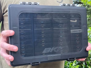 An angler holding the BKK Fully Loaded OCD Tackle Storage System with both hands