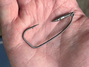 A weighted BKK hook shown in the palm of an angler's hand