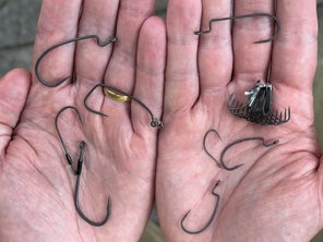 All of the unweighted hook styles shown in the palms of an angler's hands