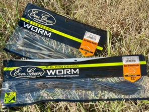 A bag of 12" and 8" Evergreen Bow Worm Noodle worms sitting in tall grass