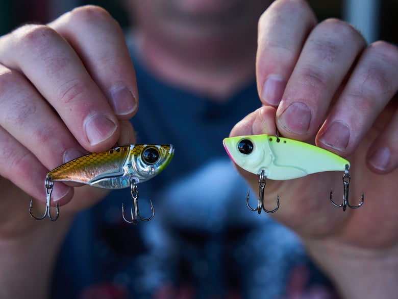 A tight shot of two damiki vault blade baits being held in each hand