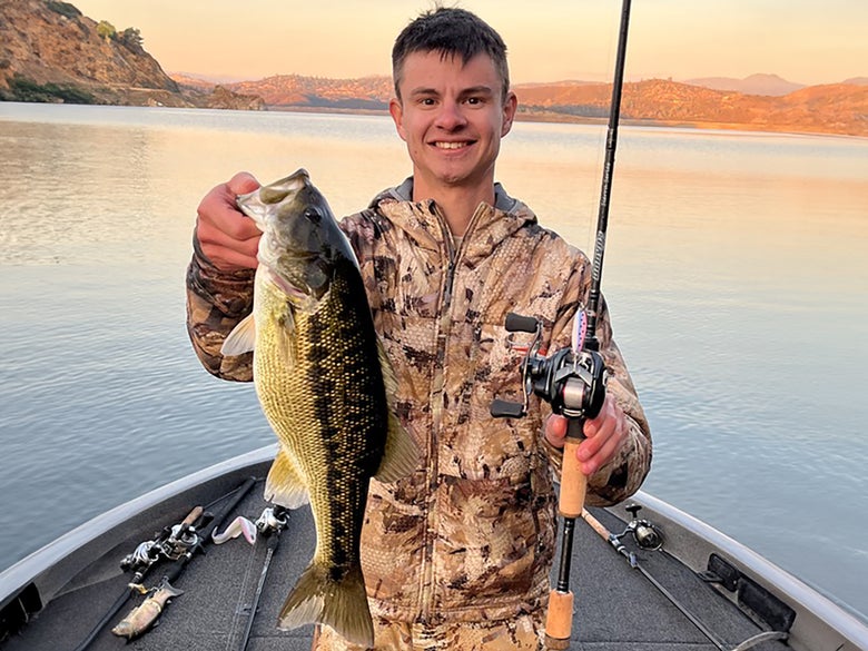 Picture of angler holding a largemouth bass while displaying bfs gear used to catch the fish.
