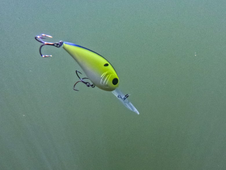 A chartreuse crankbait being retrieved through the water.