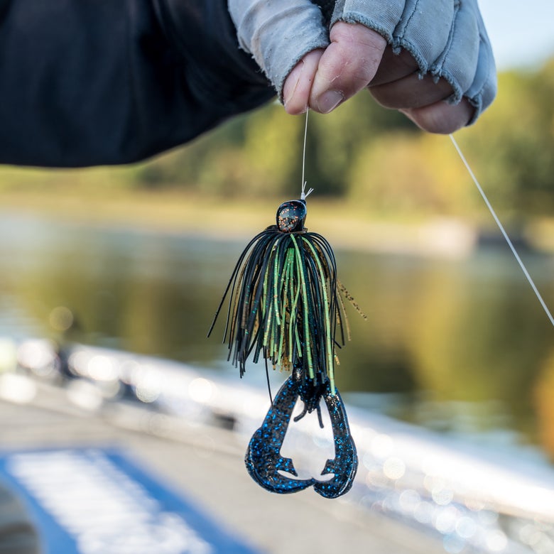 Angler holding up a jig with a craw trailer attached.