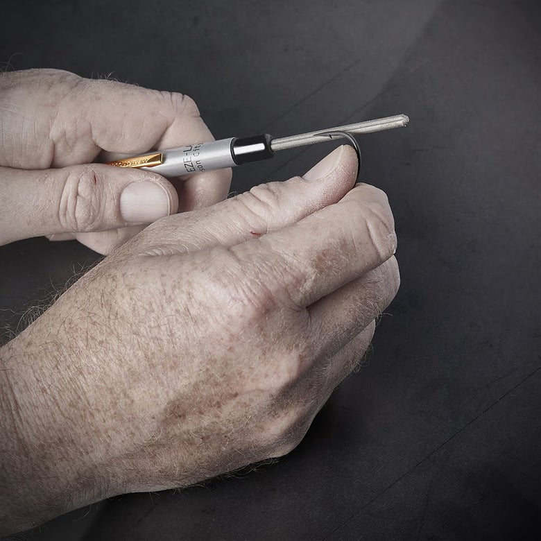 person sharpening fishing hook