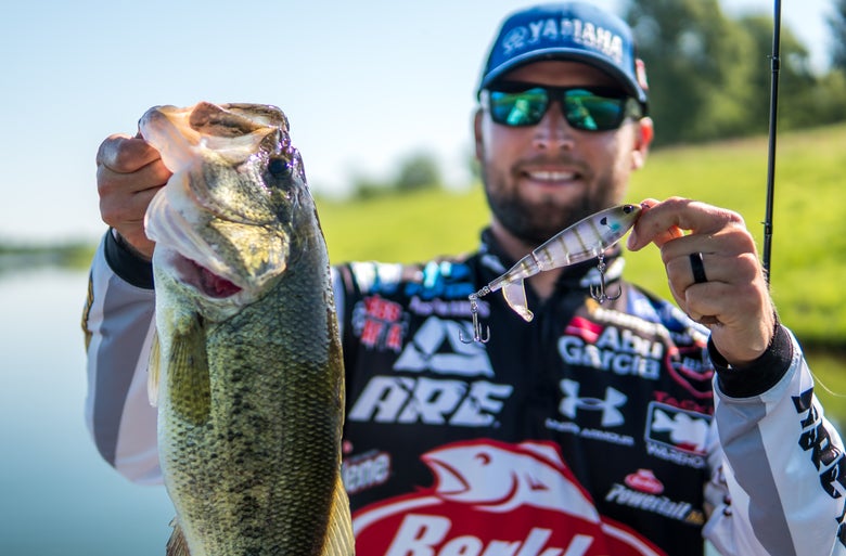 Justan Lucas holding a bass and topwater plopper
