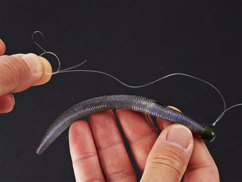 Tying on a stinger hook to a shakey head rig.