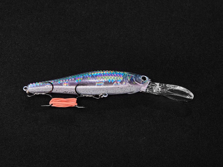 Jerkbait with a rubber band around its two treble hooks.