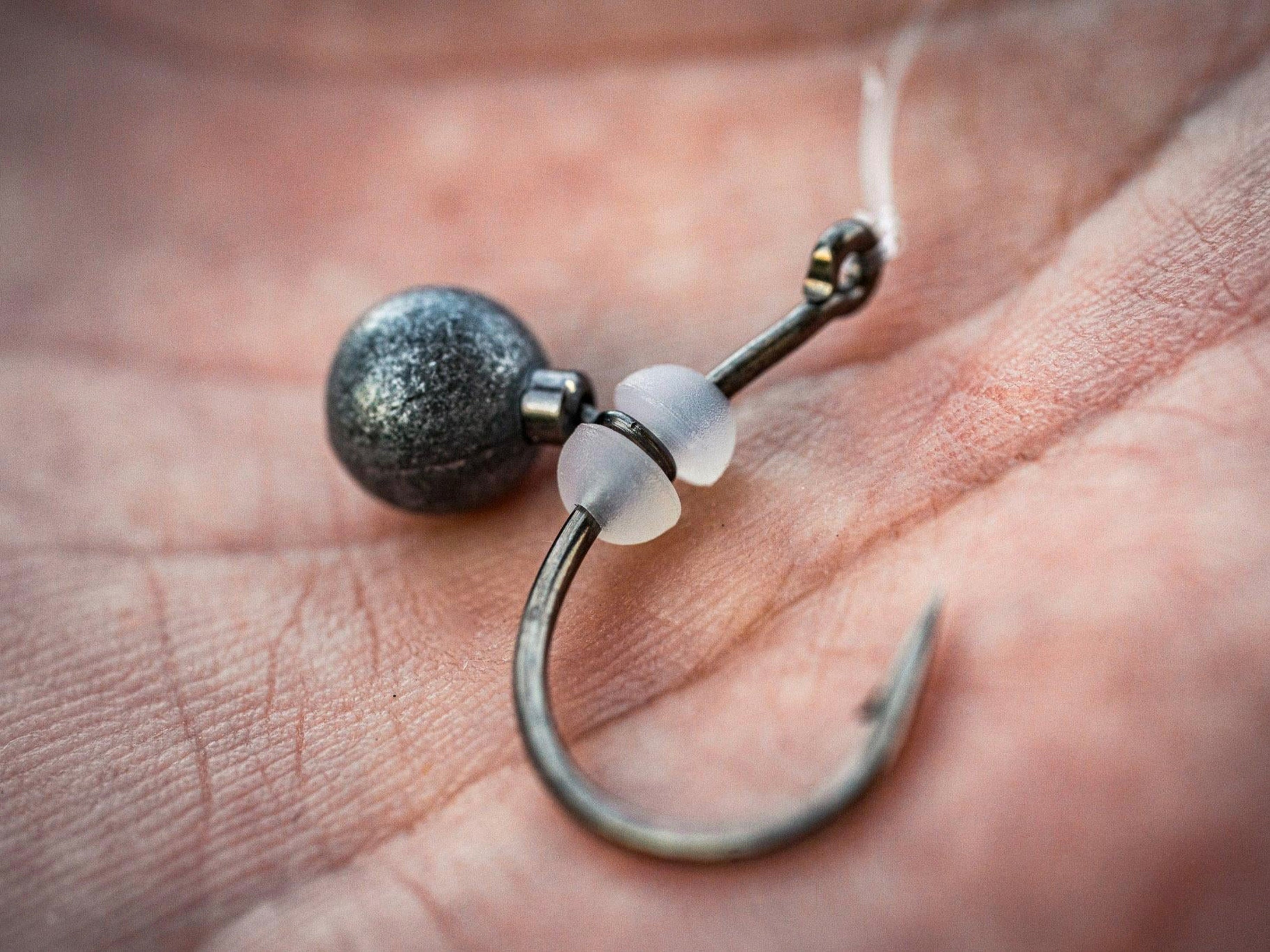 Closeup of the 6th Sense Rig Dots Soft Bait Keepers rigged on a hook with a round dropshot-style weight in between