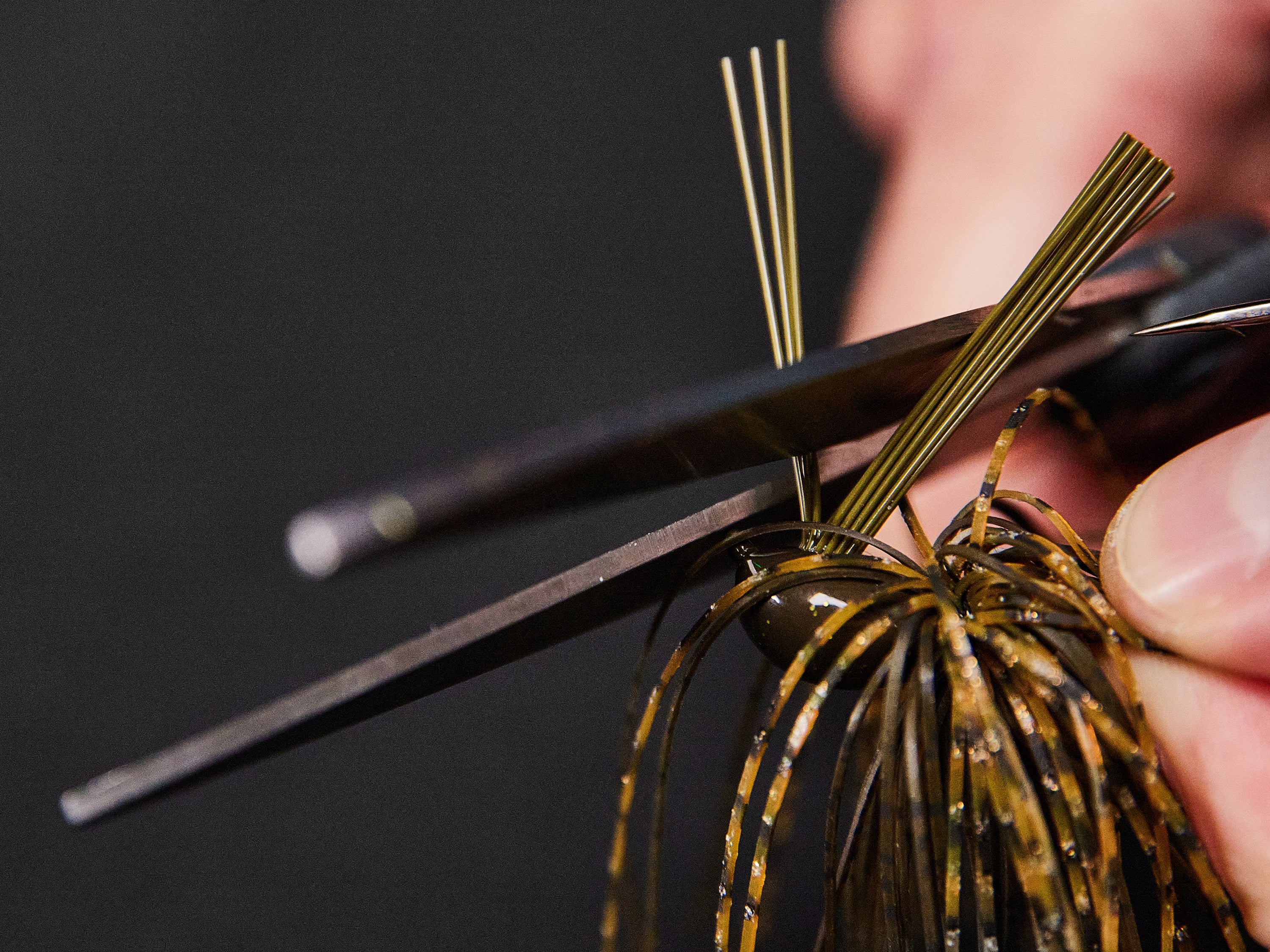 Thinning a weedguard by cutting a few of the fibers with scissors.